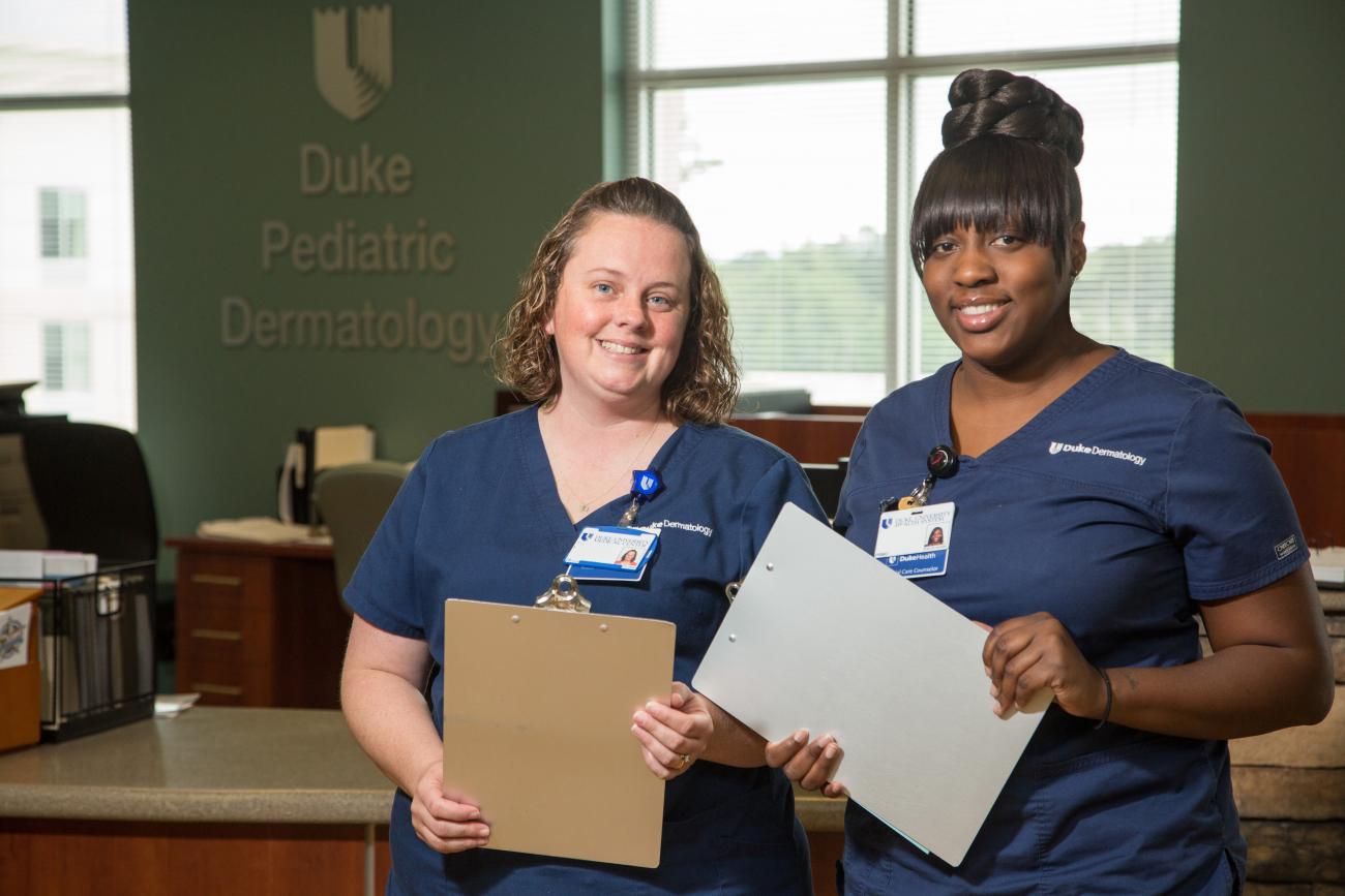 Two nurses holding clip boards